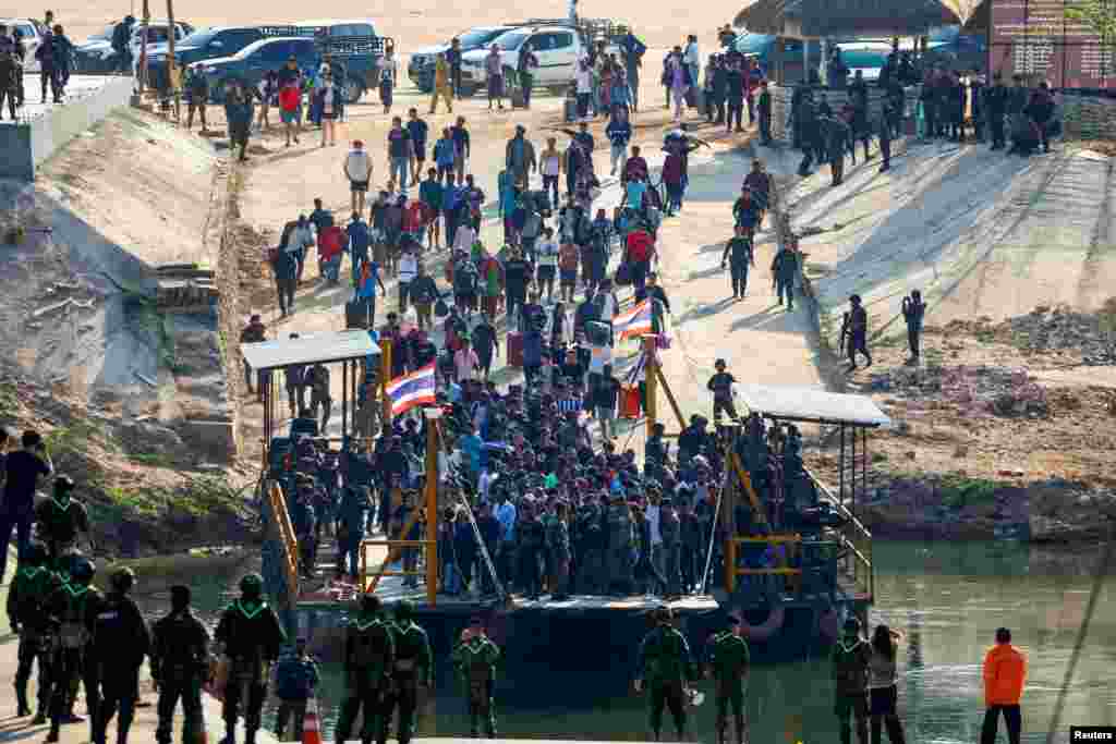 Multinational victims of scam centers, who were tricked or trafficked into working in Myanmar, walk towards a vessel to cross Moei River to Thailand, in Phop Phra District, Tak province, Thailand, Feb. 12, 2025. 
