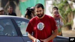 Egypt’s most prominent activist Alaa Abdel-Fattah arrives outside a court that convicted 23 activists of staging an illegal demonstration and sentenced them each to three years in jail, in Cairo, Egypt, Oct. 26, 2014. 