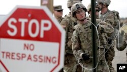 Tentara Angkatan Darat AS sedang memasang kawat berduri untuk mendirikan tenda bagi pasukan dekat jembatan Internasional AS-Meksiko, di Donna, Texas, 4 November 2018.