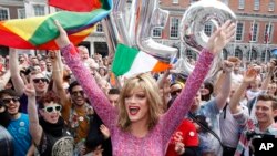 Warga merayakan hasil referendum yang menyetujui pernikahan sesama jenis di Kastil Dublin, Irlandia (23/5). (AP/Peter Morrison)