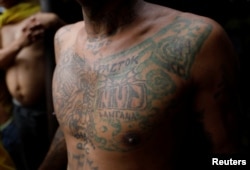 A detainee poses as he shows his tattoo inside the city jail of Quezon City, Metro Manila, Philippines, July 8, 2017.