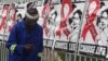A man uses his mobile phone while passing World AIDS Day banners in Sandton, Johannesburg, South Africa, Dec. 1, 2014.