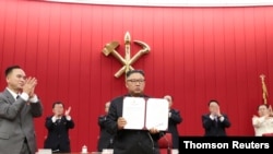 북한 김정은 국무위원장이 17일 평양에서 열린 노동당 중앙위원회 제8기 제3차 전원회의 3일차 회의에서 자신이 서명한 문서를 들어보이고 있다.