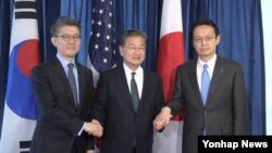 27일 미국 국무부에서 열린 미한일 6자회담 수석대표 협의에서 김홍균 한국 외교부 한반도 평화교섭본부장(왼쪽부터)과 조셉 윤 미국 국무부 대북정책특별대표, 가나스기 겐지 일본 외무성 아시아대양주 국장이 손을 맞잡고 있다.