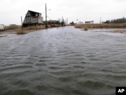 FILE - The flooded streets of a back-bay neighborhood in Manahawkin, N.J., after a moderate storm, March 14, 2017.