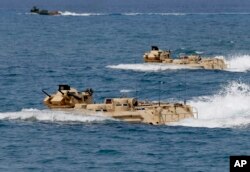 FILE - Philippine and U.S. troops prepare for a combined assault exercise at a beach facing one of the contested islands in the South China Sea known as the Scarborough Shoal in the West Philippine Sea, April 21, 2015.