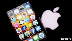 An Apple iPhone is pictured next to the logo of Apple in Bordeaux, southwestern France, Feb. 26, 2016. 