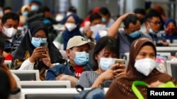 Penumpang duduk di stasiun kereta sambil menunggu untuk kembali ke kampung halaman menjelang perayaan Idul Fitri, sebuah kegiatan yang dikenal dengan sebutan "mudik", di tengah pandemi penyakit coronavirus (COVID-19), di Jakarta, Indonesia, 5 Mei , 2021. 