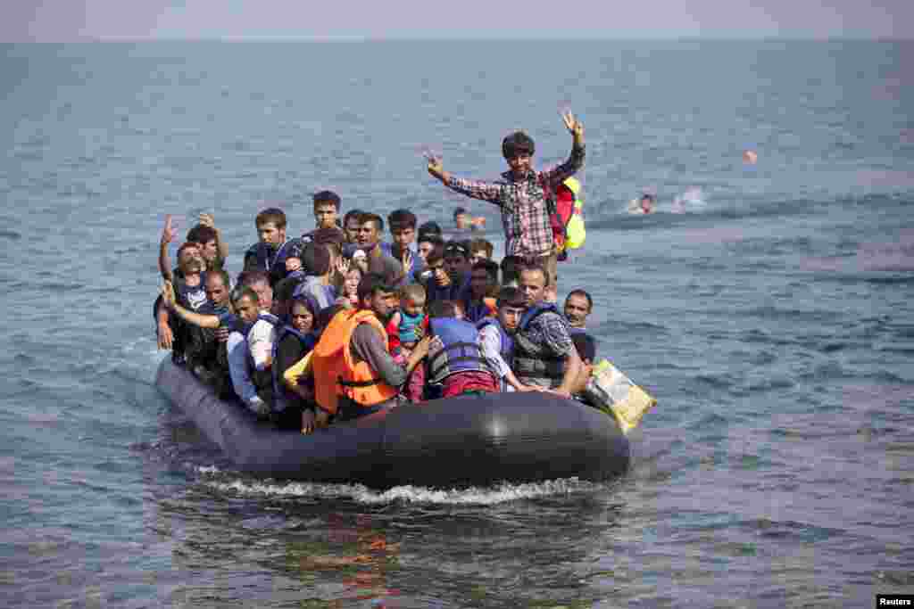 Para pengungsi Suriah dan Afhanistan di atas perahu kecil mendekati pulau Lesbos di Yunani (3/9). Organisasi Migrasi Internasional (IOM) mengatakan 1.500-2.000 orang mengambil rute melewati Yunani, Makedonia dan Serbia ke Hungaria setiap hari dan ada "kemungkinan nyata" aliran itu dapat meningkat menjadi 3.000 per hari. (Reuters/Dimitris Michalakis)