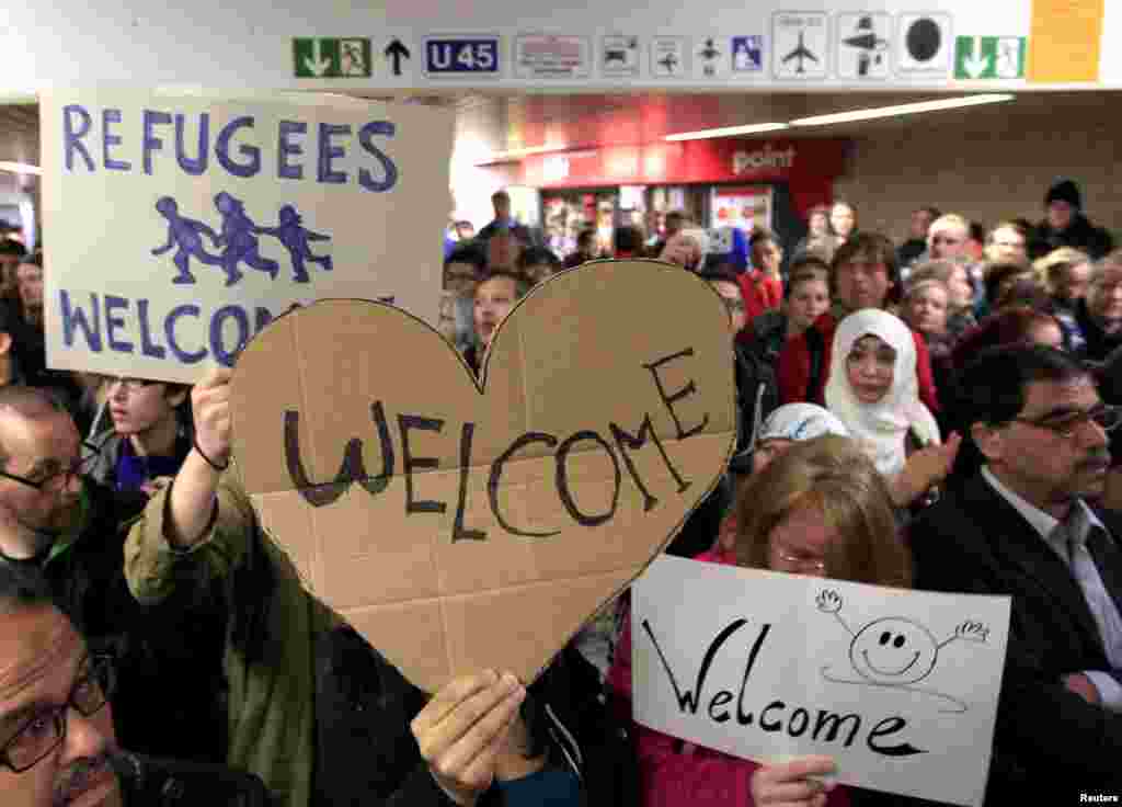 Wellwishers wave to migrants arriving at the main railway station in Dortmund, Germany, Sept. 6, 2015. Austria and Germany opened their borders to thousands of exhausted migrants, bussed to the Hungarian border by a right-wing government that had tried to stop them but was overwhelmed by the sheer numbers reaching Europe's frontiers.