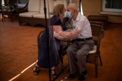 Pasangan lain: Agustina Canamero, 81 tahun, dan Pascual Perez, 84 tahun terpaksa berciuman dibatasi oleh plastik di panti jompo di Barcelona, di tengah pandemi COVID-19 di Spanyol (foto: dok).