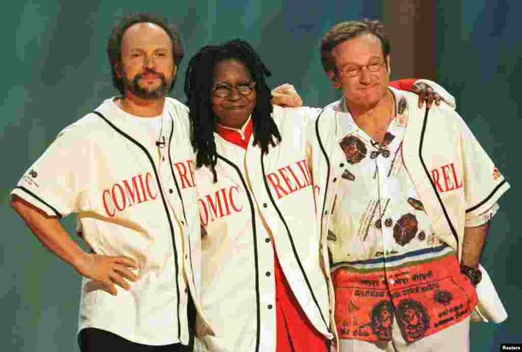 Komedian Robin Williams (kanan), Billy Crystal (kiri) dan Whoopi Goldberg saling merangkul di panggung Radio City Music Hall, New York di akhir acara "Comic Relief 8" HBO, 14 Juni 1998. Mereka menjadi pembawa acara yang mengumpulkan dana untuk proyek tunawisma di lebih dari 20 kota-kota Amerika.