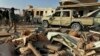 Para kombatan milis Kataeb Hezbollah atau Brigade Hezbollah, memeriksa kerusakan pada markas mereka setelah serangan udara di Qaim, Irak, 30 Desember 2019. 