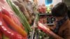 A shopper reads packaging on vegetables on sale at Veggies, a grocery shop in central Hanoi listed on a website providing consumers with information on where to buy &quot;safe&quot; vegetables, March 28, 2014. (Marianne Brown/VOA)