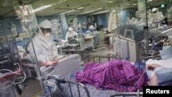 A medical worker checks a coronavirus disease (COVID-19) patient at the intensive care unit (ICU) of Bagae Hospital in Pyeongtaek, South Korea, November 29, 2021. REUTERS/Kim Hong-Ji