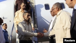 Jordanian peacekeepers Hasan Al-Mazawdeh (front) and Qasim Al-Sarhan are welcomed by officials as they arrive at Khartoum Airport, January 2, 2013, after 136 days of captivity in Sudan's Darfur region according to local media.