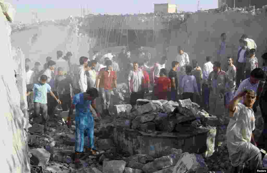 Men search for bodies under rubble of a house destroyed by a Syrian Air force air strike, in Tel Rafat, about 37 kilometers north of Aleppo, Syria, August 8, 2012.