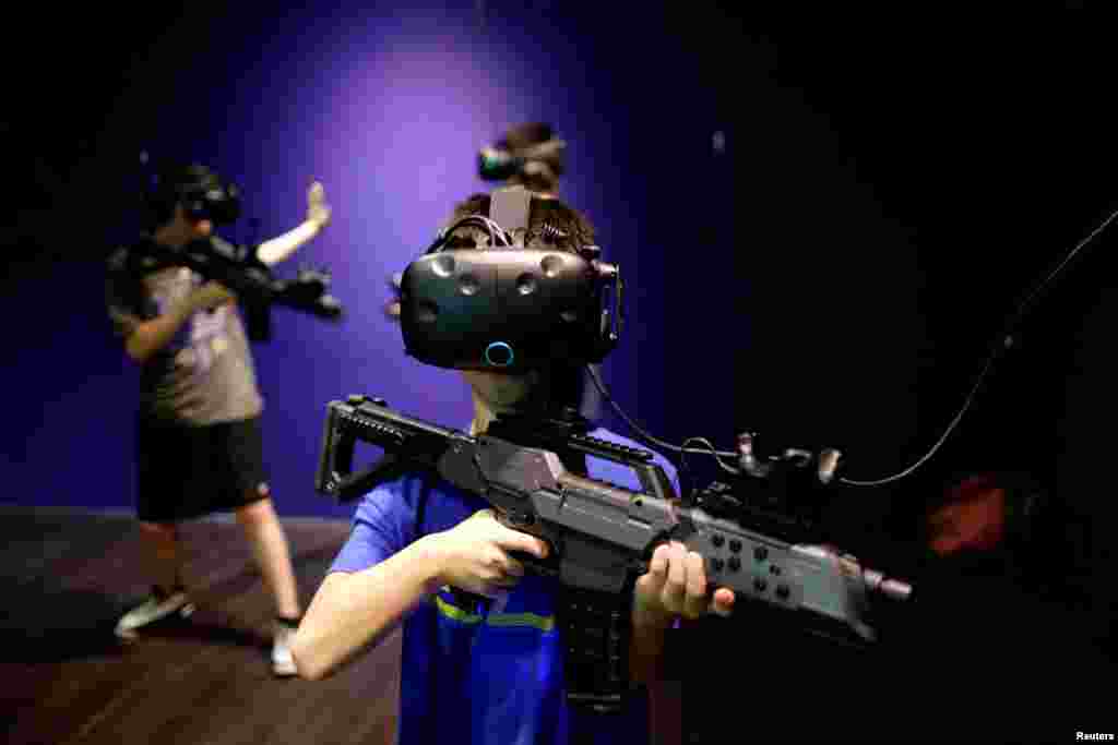 2010年8月1日,台北,在台湾第一家 Viveland VR 虚拟实境乐园,孩子们戴着 HTC Vive Virtual Reality(VR)头盔和眼镜玩耍。