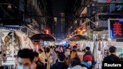 People visit a street market almost a year after the global outbreak of the coronavirus disease (COVID-19) in Wuhan, Hubei province, China December 7, 2020. Picture taken December 7, 2020. REUTERS/Aly Song