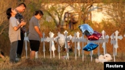 Miranda Hernandez (L) prays at sunset with father Kenneth and mother Irene at a row of crosses near the site of the shooting at the First Baptist Church of Sutherland, Texas, Nov. 6, 2017. 