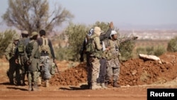FILE - Rebel fighters gather during their advance toward the Islamic State-held city of al-Bab, northern Syria, Oct. 26, 2016. 
