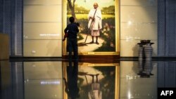 Seorang anak sedang memperhatikan lukisan ikon perjuangan kemerdekaan India, Mahatma Gandhi, yang dipamerkan di Museum President's House di New Delhi, India, 28 Juli 2018.