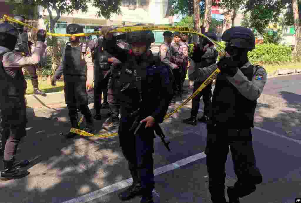 Petugas kepolisian membentangkan garis polisi di lokasi dekat terjadinya ledakan di gereja Santa Maria di Surabaya, Jawa Timur, Indonesia, Minggu, 13 Mei 2018. Ledakan ini dilaporkan telah menewaskan sejumlah orang.
