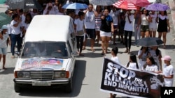 Relatives and supporters follow the hearse of Leover Miranda during his funeral, Aug. 20, 2017 in Manila, Philippines. 