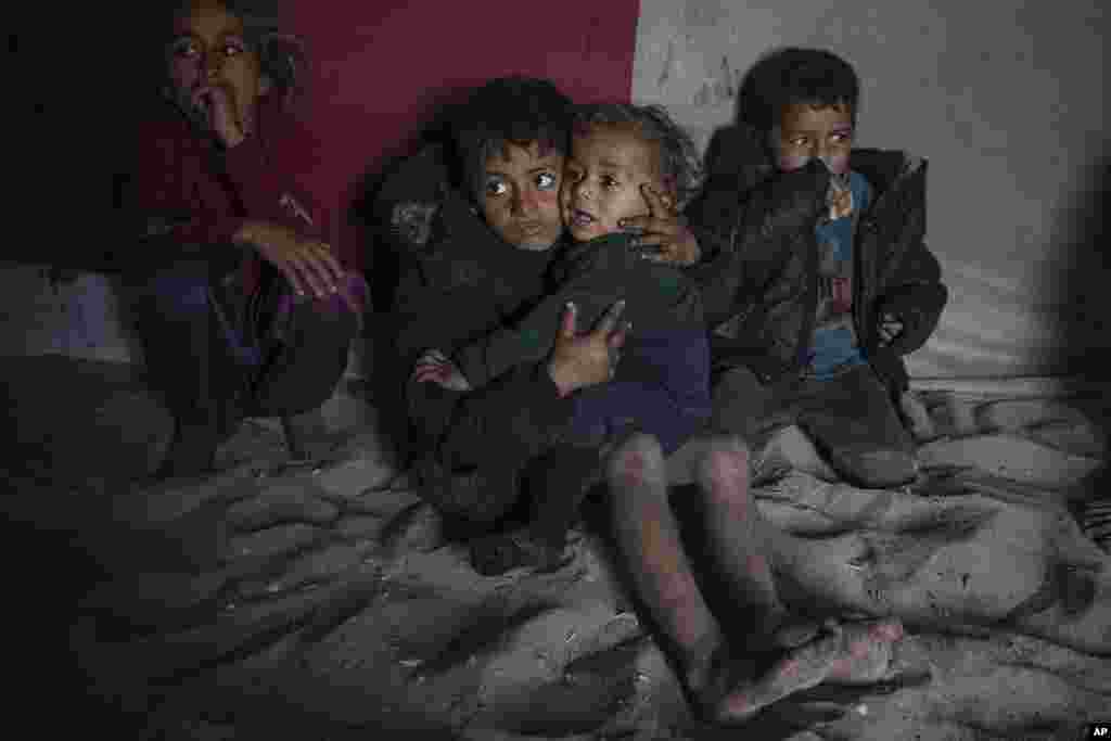 Palestinian children sit inside their family's tent at a camp for internally displaced Palestinians on the beachfront in Deir al-Balah, central Gaza Strip.