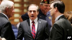 FILE - In this Dec. 14, 2015, file photo, U.S. Department of Veterans Affairs for Health Undersecretary Dr. David Shulkin (c) talks with attendees prior to testifying about the current state of the VA Medical Center in Phoenix at a Senate Veterans' Affairs Committee field hearing in Gilbert, Ariz.