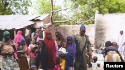 Seorang tentara Nigeria berbicara dengan beberapa perempuan dan anak-anak yang berhasil diselamatkan dari Boko Haram di Yola, 29 April. Militer Nigeria kembali berhasil menyelamatkan ratusan perempuan dan anak-anak pada 30 April. (REUTERS)