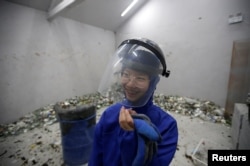 High school student Qiu Siyu, wearing protective gear, reacts after smashing wine bottles in an anger room in Beijing, China January 12, 2019. Picture taken January 12, 2019.