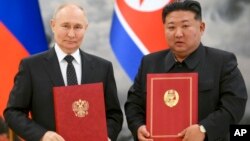 블라디미르 푸틴 러시아 대통령(왼쪽)과 김정은 북한 국무위원장이 2024년 6월 19일 북한 평양에서 열린 새로운 북러조약 조인식에서 사진 촬영을 위해 포즈를 취하고 있다.
