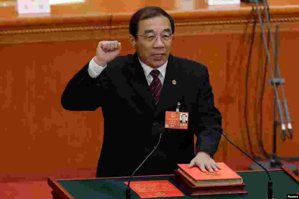 2018年3月18日,新当选的中国国家监察委员会主任杨晓渡在全国人民代表大会第六次全体会议上手抚宪法宣誓就职。在习近平担任中共上海市委书记时,杨晓渡是上海市委常委和统战部长。近年来他是中共中央纪律检查委员会副书记、国务院监察部长、预防腐败局局长。