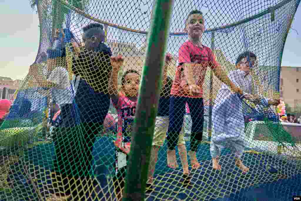   Swings for children are a common theme in front of Egypt's mosques during Eid prayers. (H. Elrasam/VOA)