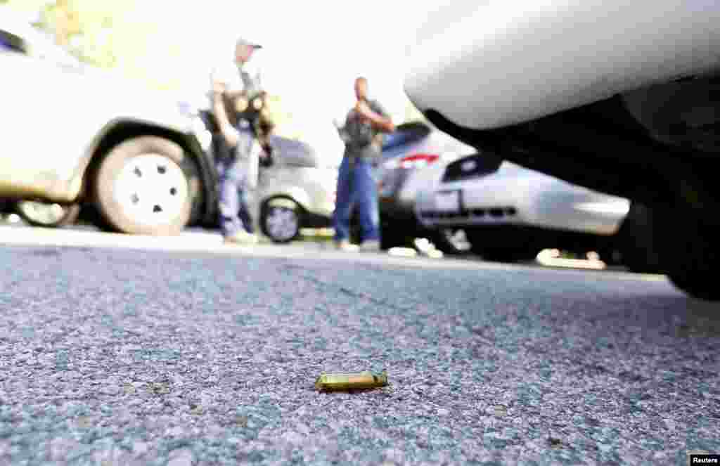 A spent cartridge lies on the ground.