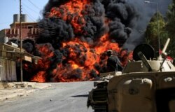 FILE - Smoke rises during clashes between joint troops of Iraqi army and Shi'ite Popular Mobilization Forces (PMF) against the Islamic State militants in Tal Afar, Iraq, Aug. 26, 2017.