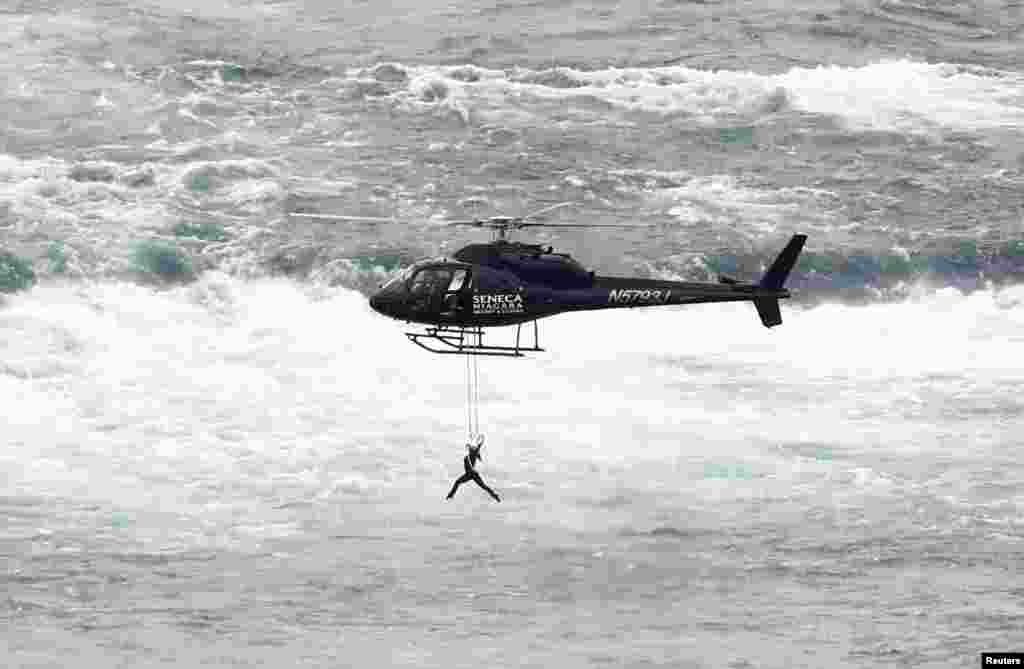 美国空中飞人埃伦迪拉&middot;瓦伦达（Erendira Wallenda） 吊在直升机上表演杂技，在加拿大一侧飞越尼亚加拉瀑布（6月17日）。她的丈夫尼克&middot;瓦伦达2012年6月15日走钢丝成功穿越尼亚加拉瀑布，成为史上这么做的第一人。
