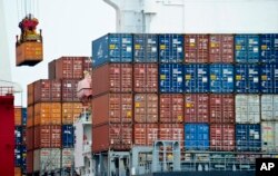 FILE - A container is loaded onto a cargo ship at Tianjin port in China.