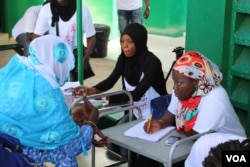 Para perempuan sedang mendaftar pemeriksaan gratis kanker payudara dan kanker leher rahim yang diadakan organisasi nirlaba Junior Chamber International di pusat kesehatan Philippe Maguilen Senghor di Yoff, Dakar, Senegal, 22 April 2017. (S. Christensen/VOA)