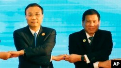 老挝万象举行的东盟会议上，中国总理李克强(左)和菲律宾总统杜特尔特(右)手拉手(资料照片)。