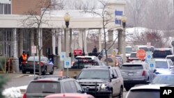 Police are shown in the parking lot of a Meijer store where Oxford High School students were being reunited with parents in Oxford, Mich., Nov. 30, 2021. Authorities say a 15-year-old sophomore opened fire at Oxford High School, killing several students.