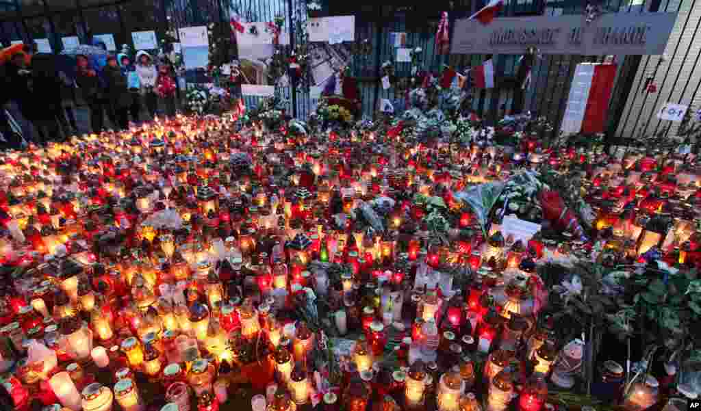 Warga menaruh bunga dan menyalakan lilin untuk para korban serangan maut di Paris, di luar Kedutaan Besar Perancis di Warsawa, Polandia (15/11). (AP/Czarek Sokolowski)