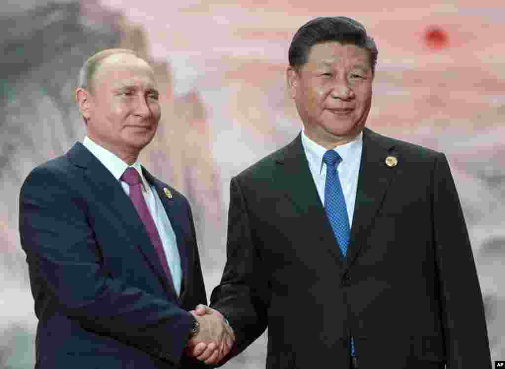 2018年6月10日中国国家主席习近平和俄罗斯总统弗拉基米尔·普京在青岛握手。根据普京的外交事务顾问尤里乌沙科夫的说法,普京和习近平共见过25次,仅过去一年就五次。