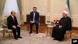Iranian President Hassan Rouhani, right, talks with U.N. nuclear chief Yukiya Amano, left, during their meeting in Tehran, Iran, Sept. 20, 2015. 