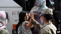 지난달 미국 워싱턴 D.C. 인근 덜레스 국제공항에 내린 아프가니스탄 출신 소녀가 미군 병사와 하이파이브하고 있다.