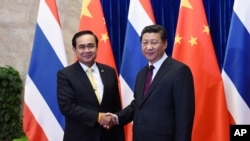 FILE - Thai Prime Minister Prayut Chan-ocha, left, shakes hands with Chinese President Xi Jinping, right, before a meeting at the Great Hall of the People in Beijing, Dec. 23, 2014.