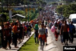 Central American migrants walk along the highway near the border with Guatemala, as they continue their journey trying to reach the U.S., in Tapachula, Mexico, Oct. 21, 2018.