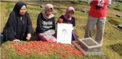 Pendamping, keluarga korban dan korban saat berziarah sambil melakukan tabur bunga di TPU Pondok Rangon, Jakarta, 13 Mei 2019. (Foto:VOA/Sasmito Madrim)