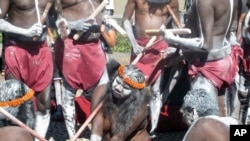 FILE - Aboriginal traditional dancers carrying clap sticks and spears and with faces painted white with clay perform in front of Parliament House in Canberra, Australia, Nov. 28, 2016.
